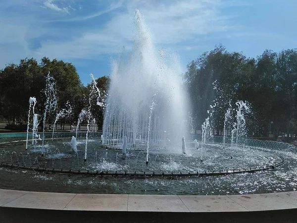 广场上的喷泉 白天喷泉的照片 在远处 天空与光云 图哈增长和喷泉工作 — 图库照片