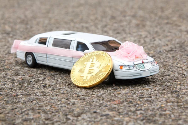 Uzun beyaz lüks araç asfalt zemin üzerine model yakınındaki Bitcoin altın sikke. Düğün gibi kabul Bitcoin ve finansal kavramı