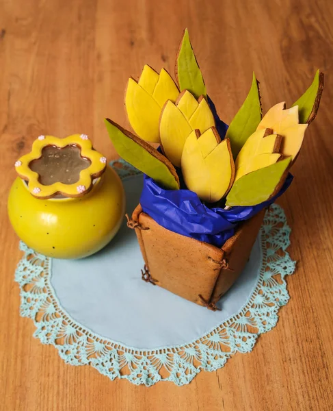 Galletas de jengibre caseras en forma de canasta de flores de tulipán en la servilleta azul cerca del orinal amarillo sobre fondo de madera. Vista de cerca — Foto de Stock
