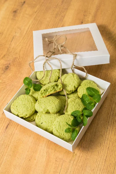 Galletas de menta con hojas de menta fresca en caja de regalo de cartón, sobre fondo de madera — Foto de Stock