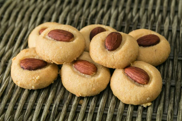 Hasır arka planda badem fıstıklı ev yapımı makarnalar.