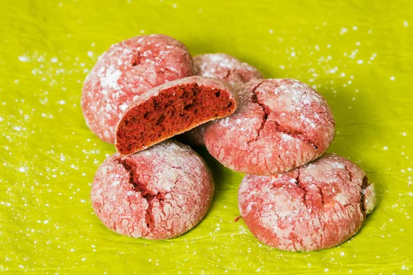 Red cookies with icing sugar isolated on green background