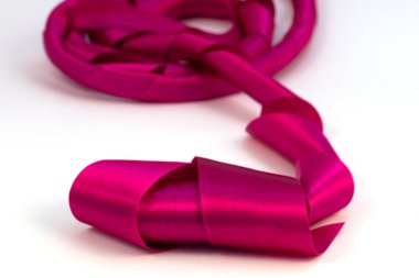 Beyaz bir arka plan üzerinde saten yapılmış bir kaset koydu rasgele biçimde uzun bobinleri ön planda bir odak ile.