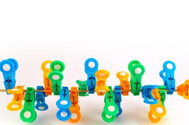 Plastik clothespins mavi, yeşil ve turuncu görüntünün altındaki farklı pozisyonlarda gergin bir ip üzerinde bir grup.