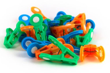 Çok renkli giysiler mandal rasgele bir şekilde beyaz bir arka plan üzerinde yığılmış ev kullanımı için bir grup.