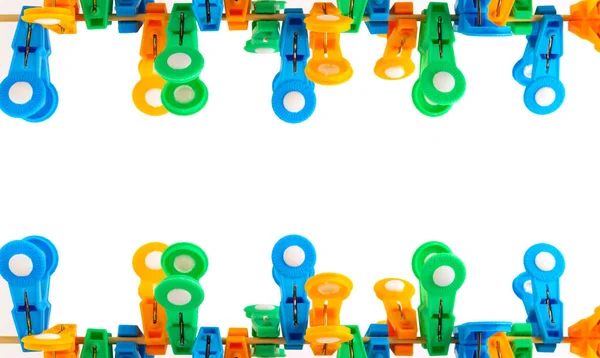 Turuncu, yeşil, mavi clothespins, üst ve alt görüntünün beyaz zemin üzerinde yer alan.