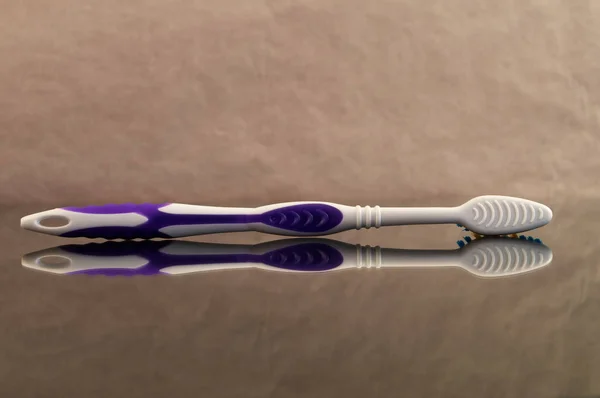 Toothbrush Made Plastic Purple Insets Handle Laid Its Side Reflection — Stock Photo, Image