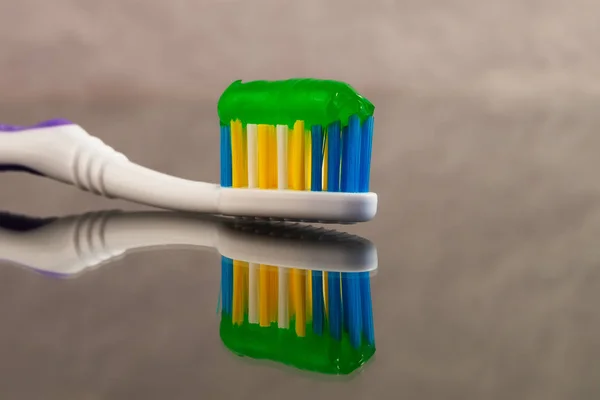 Toothbrush Multicolored Bristles Toothpaste Green Reflection Gray Abstract Background — Stock Photo, Image