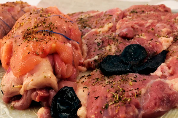 用香草和李子调味的肉片被卷成一个卷 用蓝色的线固定 以便进一步烤 — 图库照片
