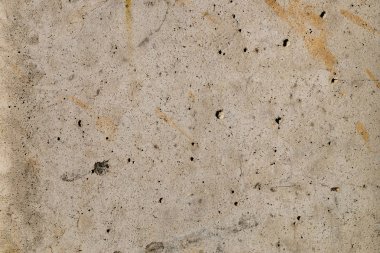 Bej renkli lekeleri ve siyah noktalar, taş doku ile beton levha yüzeyine.