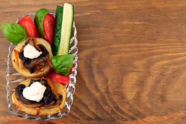 Fırında patates mantar, havuç ve dilimlenmiş domates, salatalık, fesleğen, beyaz ekşi krema üstte.