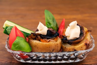 Bir güzel ve doyurucu yemek pişmiş patates, doldurulmuş mantar, soğan, havuç, taze dilim domates, salatalık ve fesleğen ile bir tabakta yaprakları koydu.