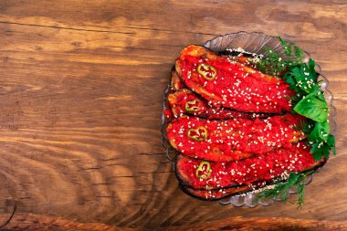 Patlıcan dilimleri, salça, biber ve maydanoz, dereotu, fesleğen ile bir cam levha koydu susam, yağda kızarmış dilimlenmiş.