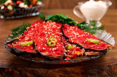 Kızarmış patlıcan, domates sos sprinkles susam, ile kaplı sebze tabağı acı biber, dereotu, fesleğen ve maydanoz ile süslenmiş.