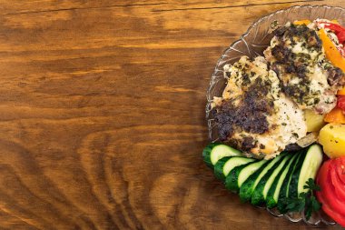 Et, dilimlenmiş ve garnitür pişmiş sebze ile kahverengi oluncaya kadar sarımsak ekşi krema sosu altında ızgara ve taze salatalık dilimlenmiş.