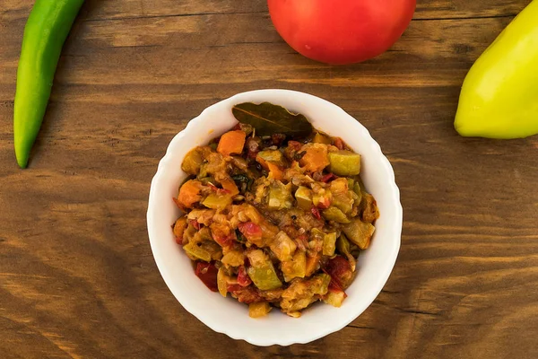 野菜ズッキーニ トマト ニンジン 玉ねぎ ピーマンの煮込み混合物が木製の表面全体の果物の背景板のレイアウト — ストック写真