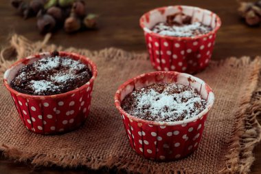 Keten kumaş ahşap zemin üzerine kırmızı pişirme kalıpları içinde pudra şekeri ile yulaf ezmeli kurabiye.