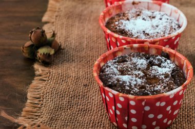 Kağıt bardak ahşap arka plan üzerinde fındık ile keten kumaş üzerine pudra şekeri ile pişirme için pişirme.