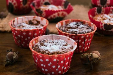 Kurabiye pişirme çanağı kırmızı, fındık ve keten ahşap arka plan üzerinde bir peçete.