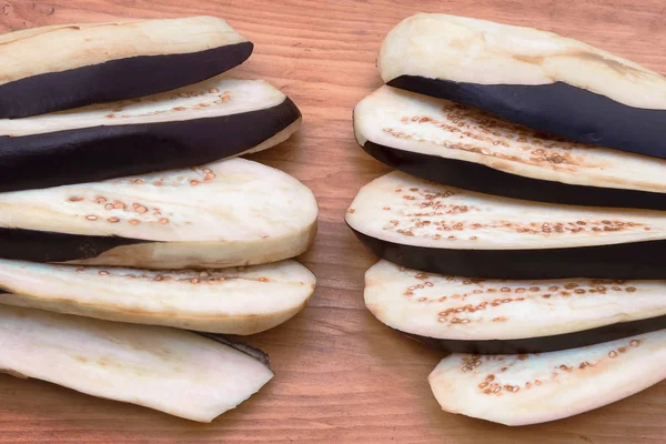 Ahşap arka plan üzerinde bir fan ile patlıcan, daha sonra yemek için geniş düz dilimler halinde kesip koydu.