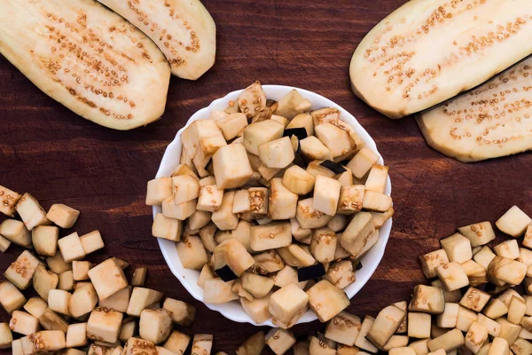 Patlıcan Tarifi küpler şeklinde kullanmak için ezilmiş ve geniş düz ahşap bir arka plan üzerine dilimler.