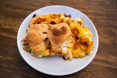 Elma, peynir ve peynir ahşap arka plan üzerinde beyaz porselen tabakta ile güveç.