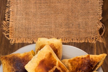 Kaba kumaş, ahşap arka plan üzerinde üstten görünüm peçete puf böreği peynir ve bir plaka üzerinde elma ile yapılan.