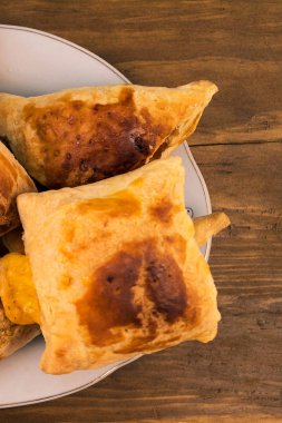 Tatlı yemek pişmiş çörekler peynir ile doldurulmuş ve elma tabakta, yukarıdan bir ahşap zemin üzerine koydu.