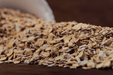 Tablo, her bir ahşap zemin üzerine devrilmiş beyaz kase döktü yulaf gevreği yakın çekim.