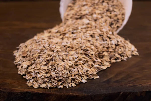 Cereal, spilled a bunch on the table from the fallen porcelain bowl closeup on wooden background.