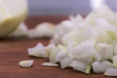 Küçük parçalar beyaz soğan bir ahşap arka plan üzerinde kesme yakın çekim.