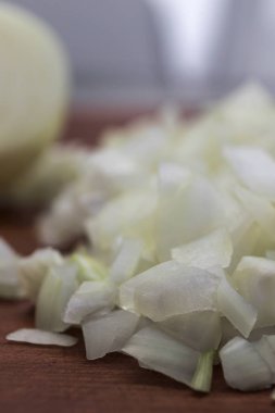 Küçük parçalar beyaz soğan, yakın çekim bir ahşap arka plan, dikey çerçeve içine doğranmış.