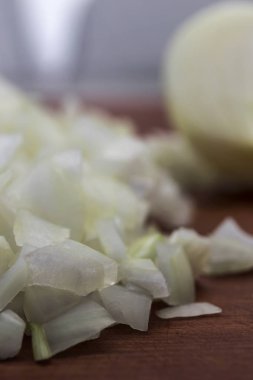 Yarım bir soğan, yakın çekim, dikey çerçeve, ahşap arka plan arka plan üzerine doğranmış soğan parçaları.