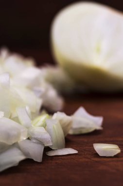 İnce kıyılmış beyaz soğan, döktü bir ahşap masa üzerinde yarım kesilmiş soğanı, dikey atış, yakın çekim.