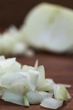 Beyaz soğan yakın çekim, dikey atış, ahşap arka plan dilimlenmiş.