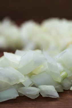 Dilimlenmiş beyaz soğan yakın çekim, dikey çerçeve, ahşap arka plan.