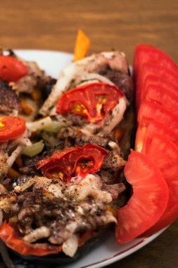 Fırında patlıcan dilim katmanları ile kavrulmuş et domates ve soğan, dilimlenmiş domates, dikey çerçeve, ahşap arka plan.