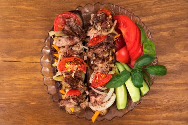 Fırında patlıcan ile et, domates, havuç ve soğan, şenlikli masaya güzel bir tabak taze sebze fesleğen yaprakları ile dilimlenmiş.