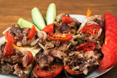 Sebze yemek fırında patlıcan domates, havuç ve soğan ile et ve dilimlenmiş salatalık ve domates, kızarmış et parçaları ile.