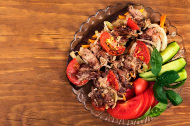 Fırında patlıcan dilimleri ile kızarmış et, domates, soğan ve havuç, üstten görünüm.