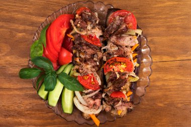 Bir kısmını katmanları kavrulmuş et, domates, soğan ve havuç koydu, fırında patlıcan fesleğen ve taze salatalık ve domates dilimleri ile dekore edilmiş.