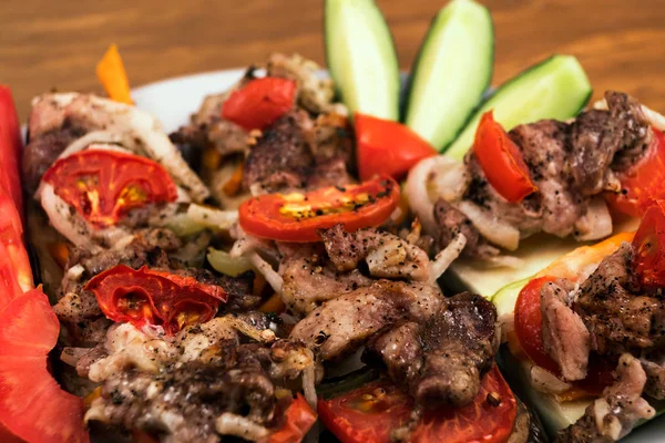 Kızarmış et, parçaları üst üste soğan ve domates ile üzerinde fırında patlıcan dilimleri, yakın çekim.