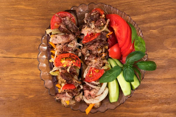 Fırında patlıcan ile et, domates, havuç ve soğan, şenlikli masaya güzel bir tabak taze sebze fesleğen yaprakları ile dilimlenmiş.