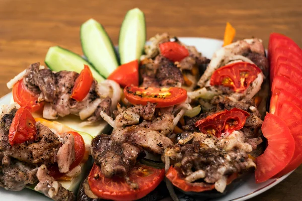 Sebze yemek fırında patlıcan domates, havuç ve soğan ile et ve dilimlenmiş salatalık ve domates, kızarmış et parçaları ile.