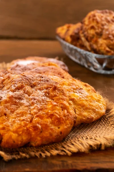 Cookies with powdered sugar powder with a ruddy crust, close-up, vertical frame.