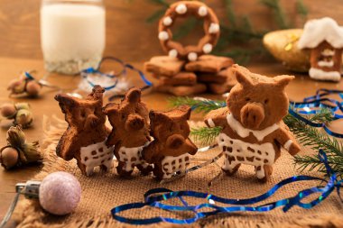 Üç küçük domuz ve hamur-Noel kurabiyeleri Noel süsleri ve bir bardak süt, 2019 sembolü yanında yapılmış anne domuz.