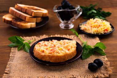 Kahvaltı tost tost ile Yengeç eti ve erimiş rendelenmiş peynir, Yeşil fesleğen yaprakları, Marine siyah zeytin.