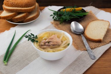 Çorba, tavuk, patates ve makarna, kepekli ekmek, maydanoz ve soğan dilimlenmiş bırakır.