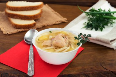 Sıcak tavuk çorbası erişte ve patates, taze maydanoz ve yeşil soğan, beyaz ekmek dilimleri ile.