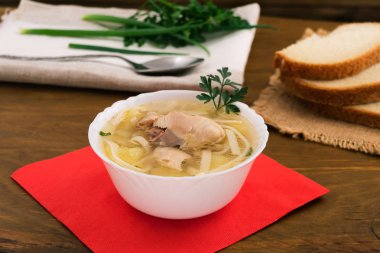 Temiz suyu ve et parçaları, beyaz derin kase kırmızı peçete, ahşap arka plan üzerinde ile tavuk erişte.